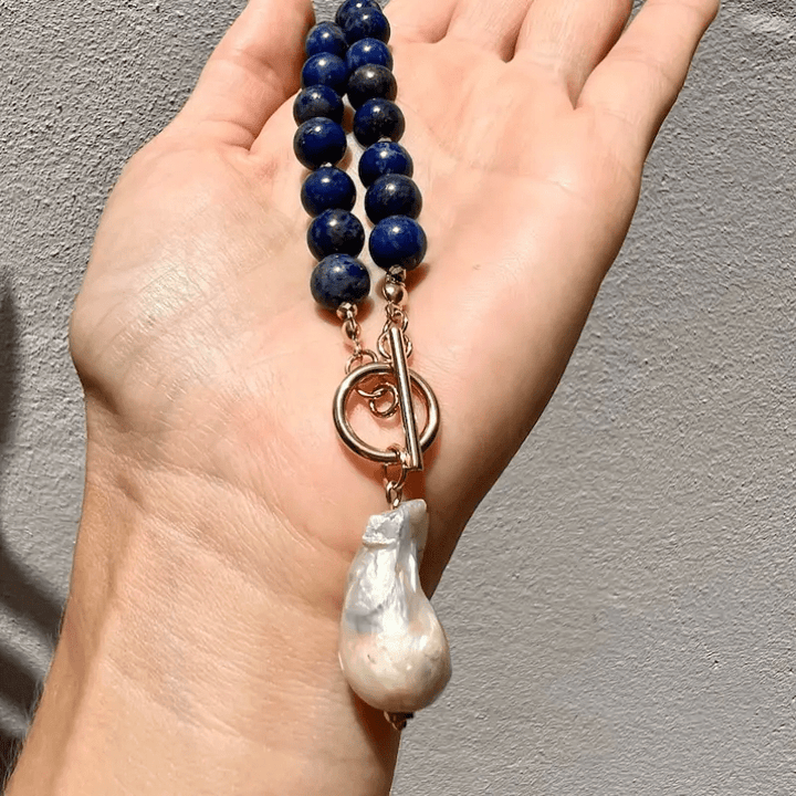 Perles bleues et fermoir à bascule tenus dans la paume, avec la grosse perle baroque en bas 3