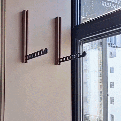 Deux supports muraux à bras noir perforé déplié, fixés sur un mur beige près d'une fenêtre. 2