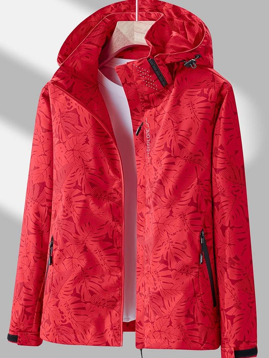 Veste rouge vif à motif de feuilles tonales, capuche doublée, zip ouvert sur un t-shirt blanc, poches latérales zippées. 5