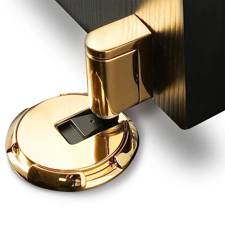 Gros plan sur l'arrêt de porte doré brillant calé contre le bas d'une porte noire 1