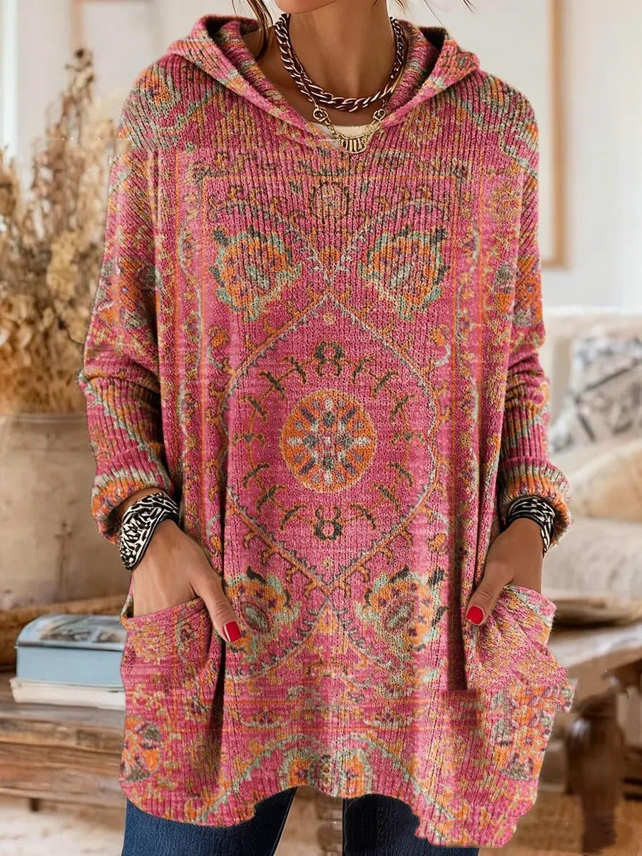 Version rose au motif de tapis orange et vert, portée par un mannequin avec capuche, manches longues et deux poches plaquées. 6
