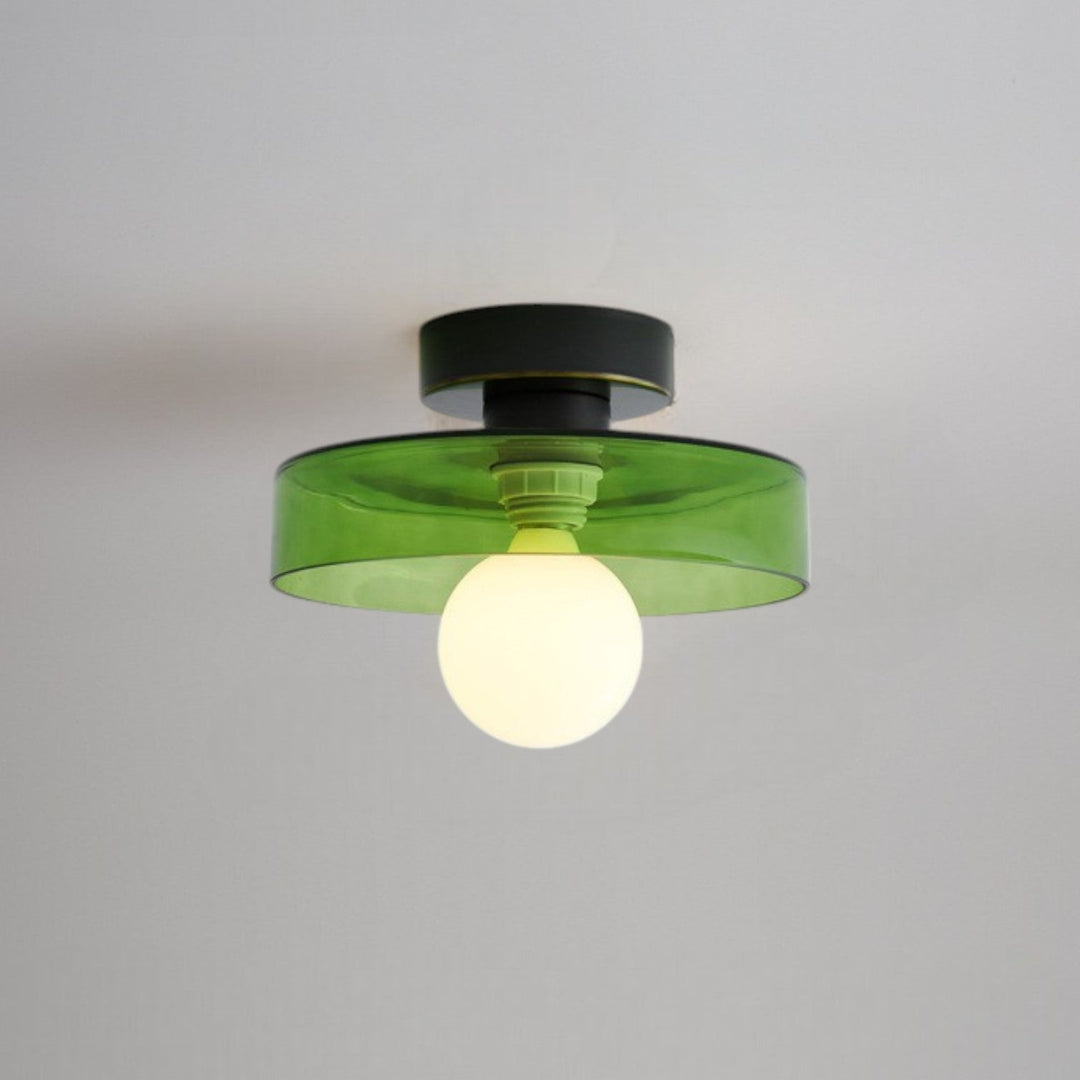Plafonnier à abat-jour en verre vert et base noire, douille verte visible, ampoule globe opaline allumée. 9