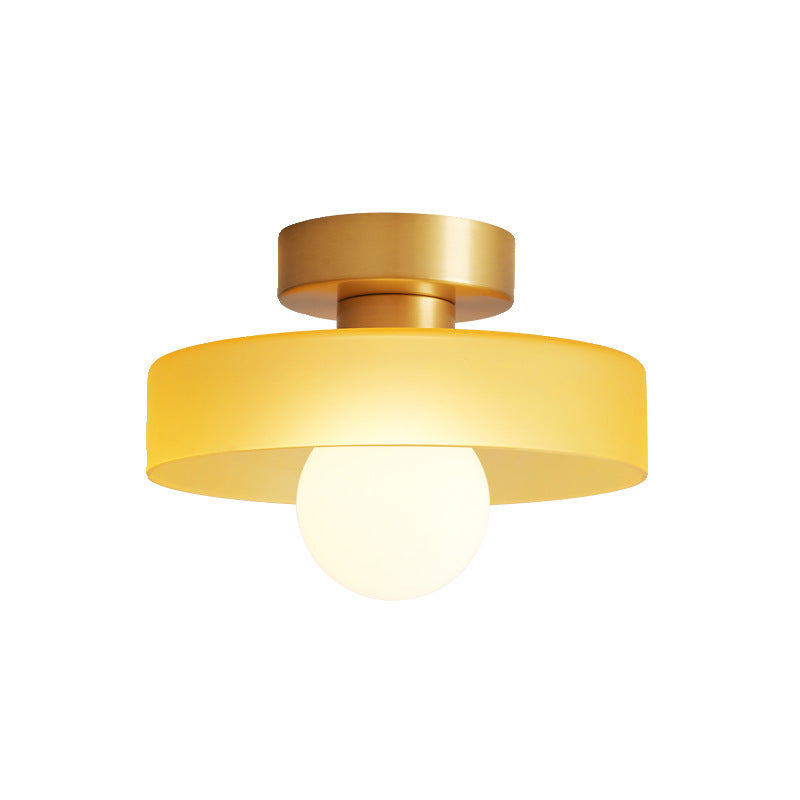Plafonnier à abat-jour jaune et base dorée en laiton, ampoule globe allumée, présenté seul sur fond blanc. 6