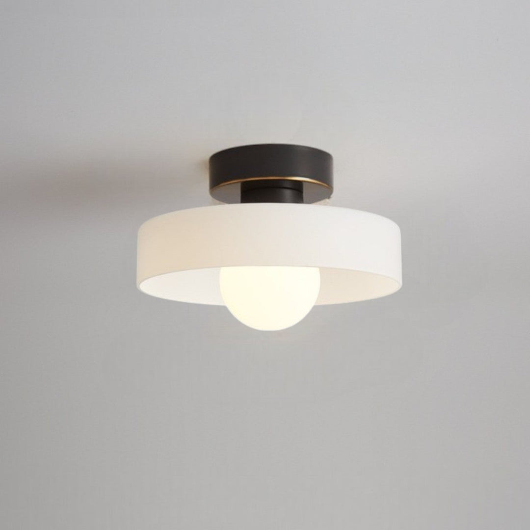 Plafonnier à abat-jour blanc mat et base noire à liseré doré, avec ampoule globe allumée, fixé au plafond. 7