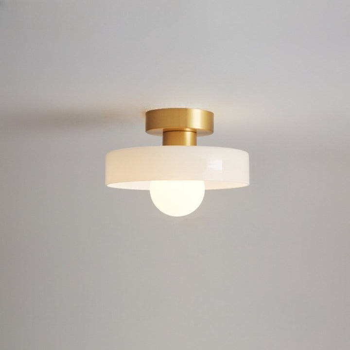 Plafonnier à abat-jour blanc brillant et base dorée, avec ampoule globe allumée, fixé au plafond. 11