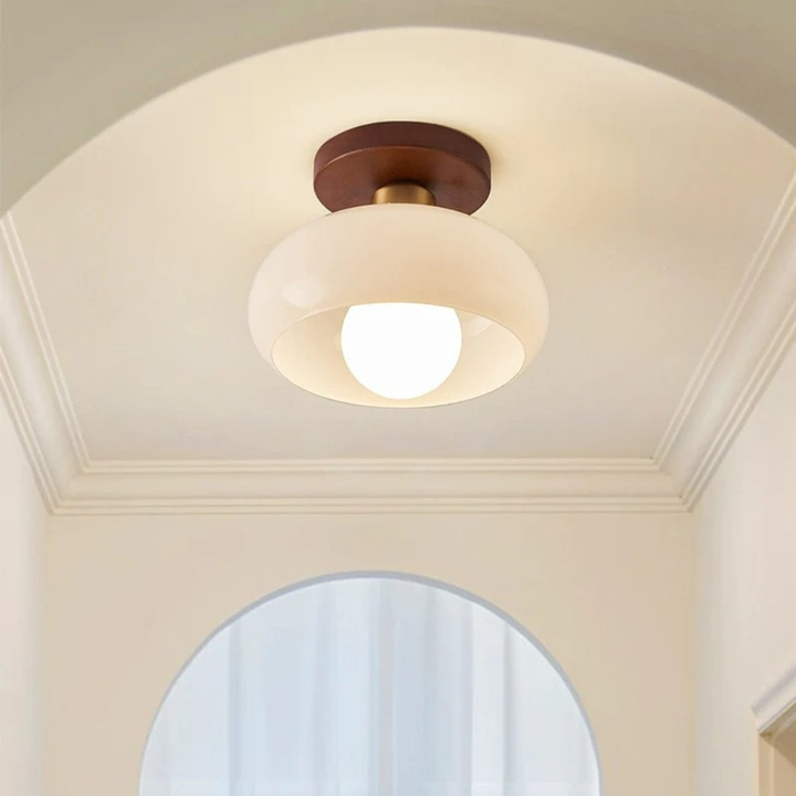 Petit plafonnier allumé dans un couloir à plafond voûté, ampoule ronde visible sous le globe 3