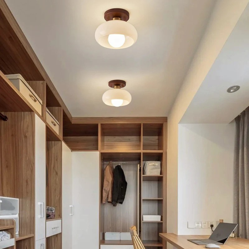Deux plafonniers allumés dans un dressing ouvert en bois, près d'un bureau avec ordinateur portable 4