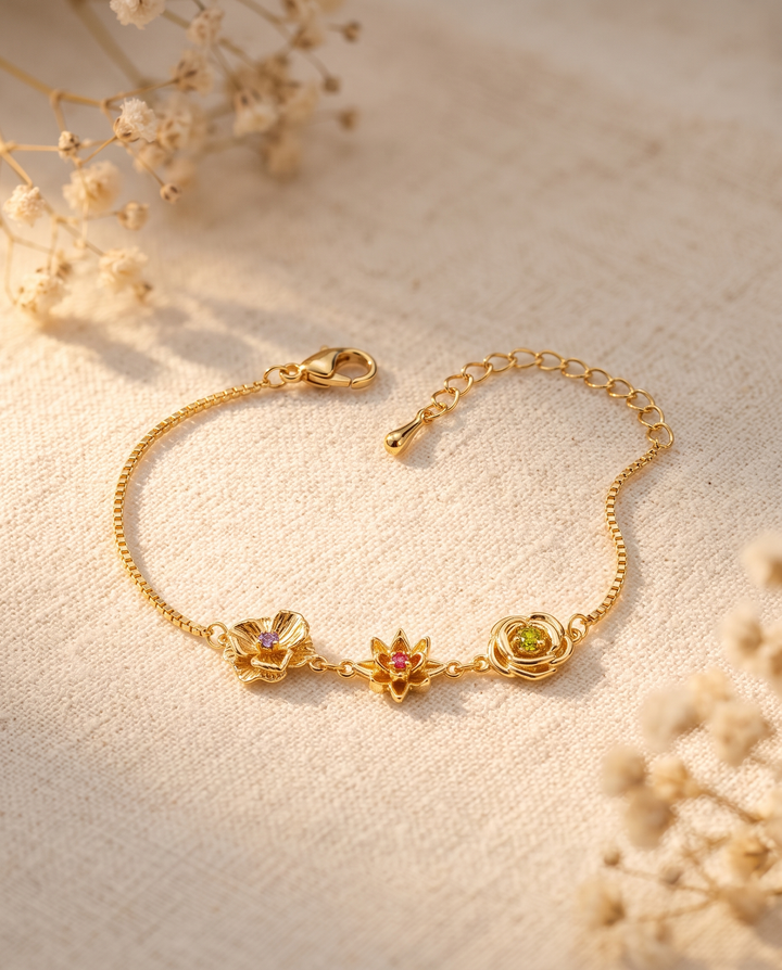 Bracelet doré posé à plat sur un tissu de lin beige, avec des brins de gypsophile séchés autour, fermoir et chaînette visibles. 12