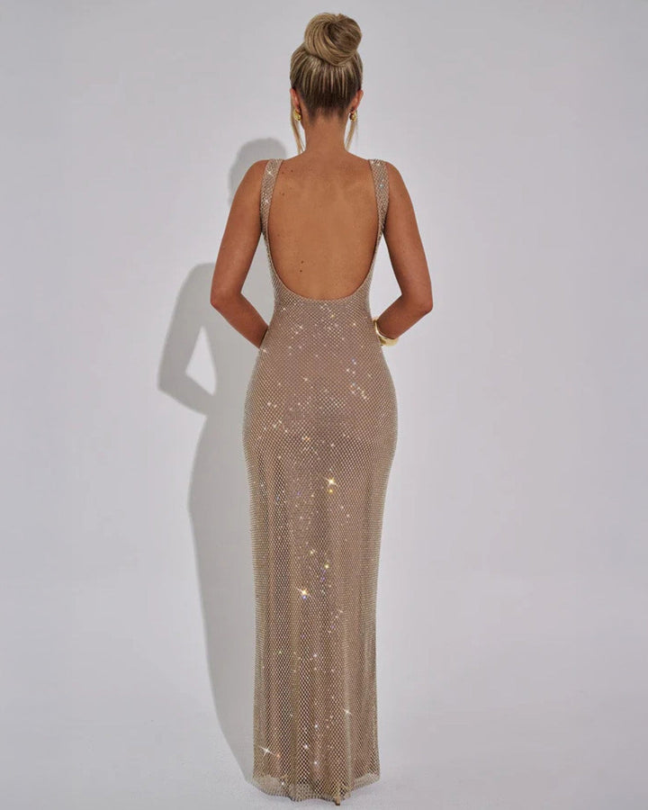 Mannequin de dos, bras le long du corps, montrant le grand décolleté dos et la coupe longue ajustée de la robe champagne. 4
