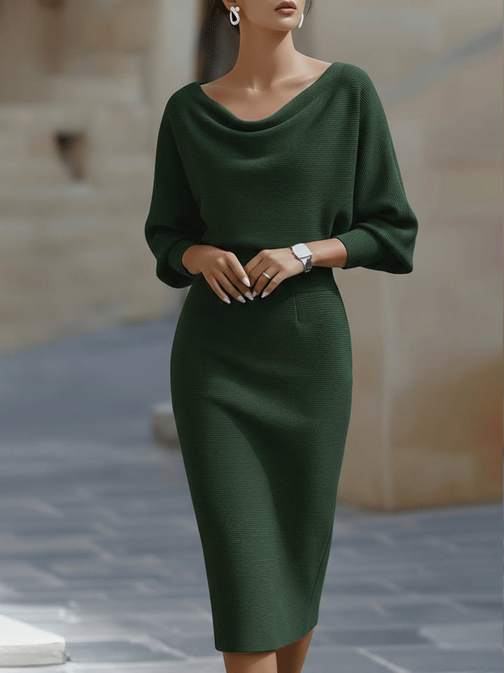 Version vert foncé portée de face par un mannequin, avec encolure drapée, ceinture marquée et jupe ajustée jusqu'aux genoux. 4