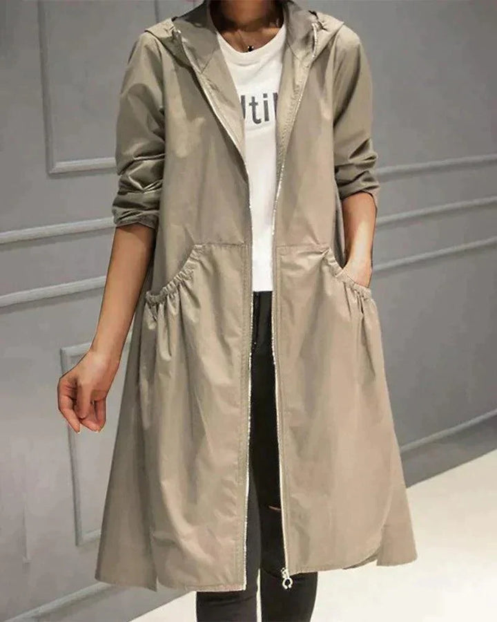 Imperméable beige à capuche porté ouvert sur un t-shirt blanc, poches froncées sur les côtés 1