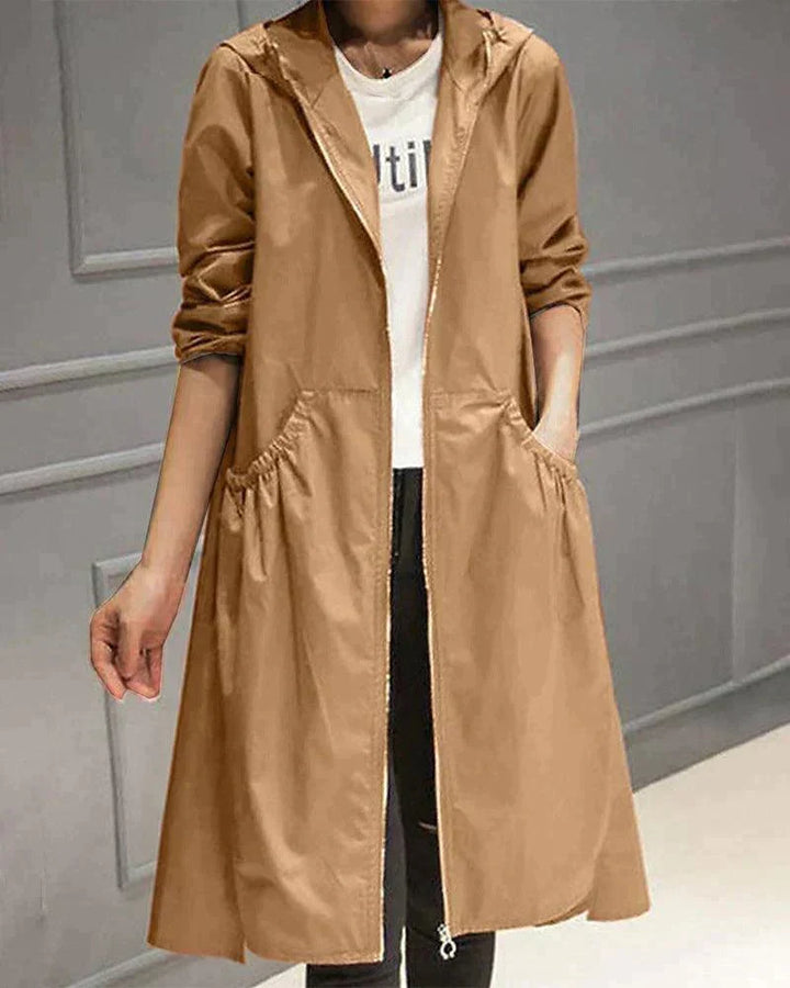 Version caramel de l'imperméable, portée ouverte avec une main dans la poche froncée, sur jean noir 3