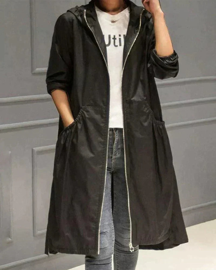 Version noire de l'imperméable, zip ouvert, une main dans la poche, portée avec un jean bleu 4