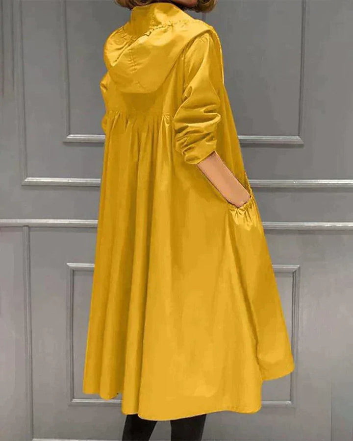 Vue de dos et de côté d'un imperméable jaune ample, capuche rabattue, main dans la poche 7