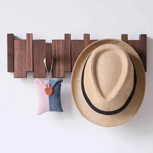 Porte-manteau en bois foncé accueillant un chapeau de paille et un petit sac en tissu rose et bleu 2