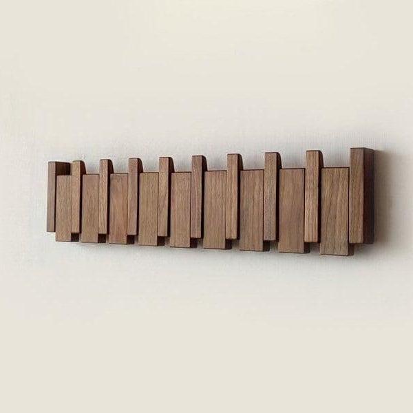 Vue de face du porte-manteau en bois foncé, tous les crochets repliés, formant une façade de lames verticales 4
