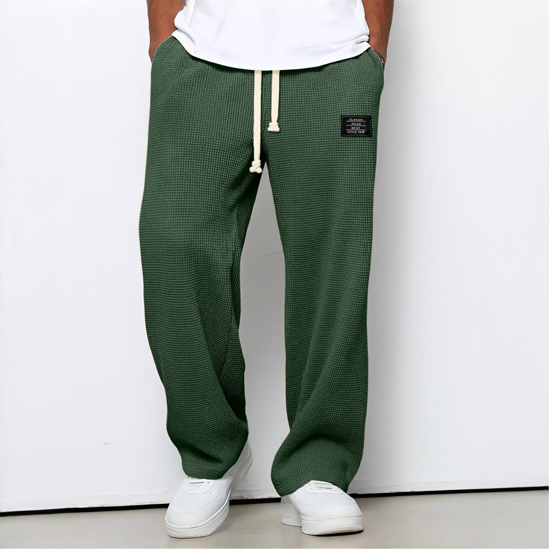 Pantalon ample vert foncé en maille gaufrée, cordon crème, porté par un modèle en baskets blanches 4