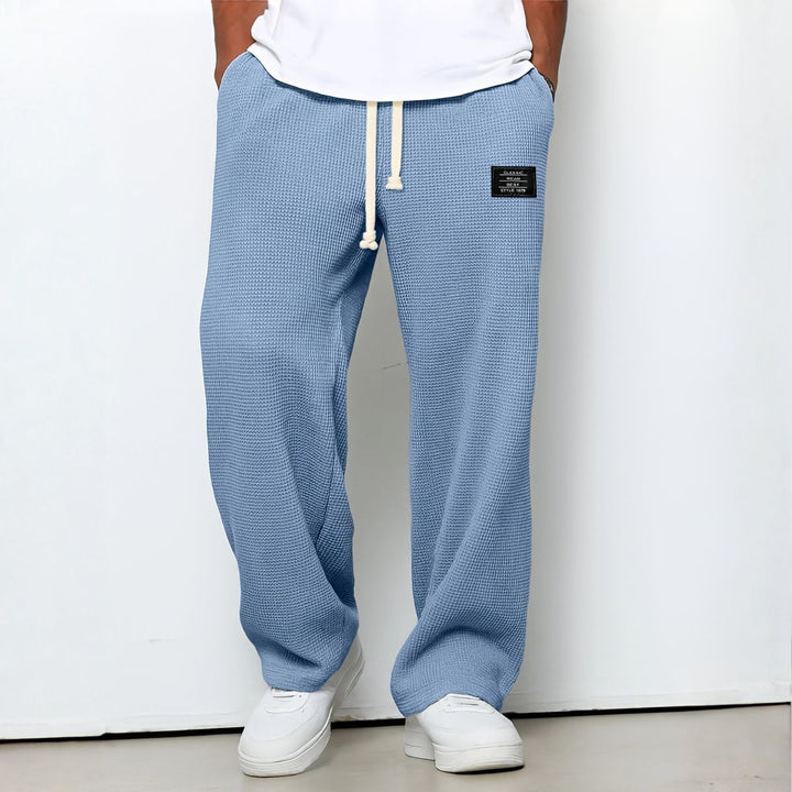Pantalon ample bleu ciel en maille gaufrée, cordon blanc à la taille, porté avec baskets blanches 1