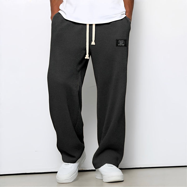 Pantalon ample gris anthracite en maille gaufrée, porté avec t-shirt et baskets blancs 3
