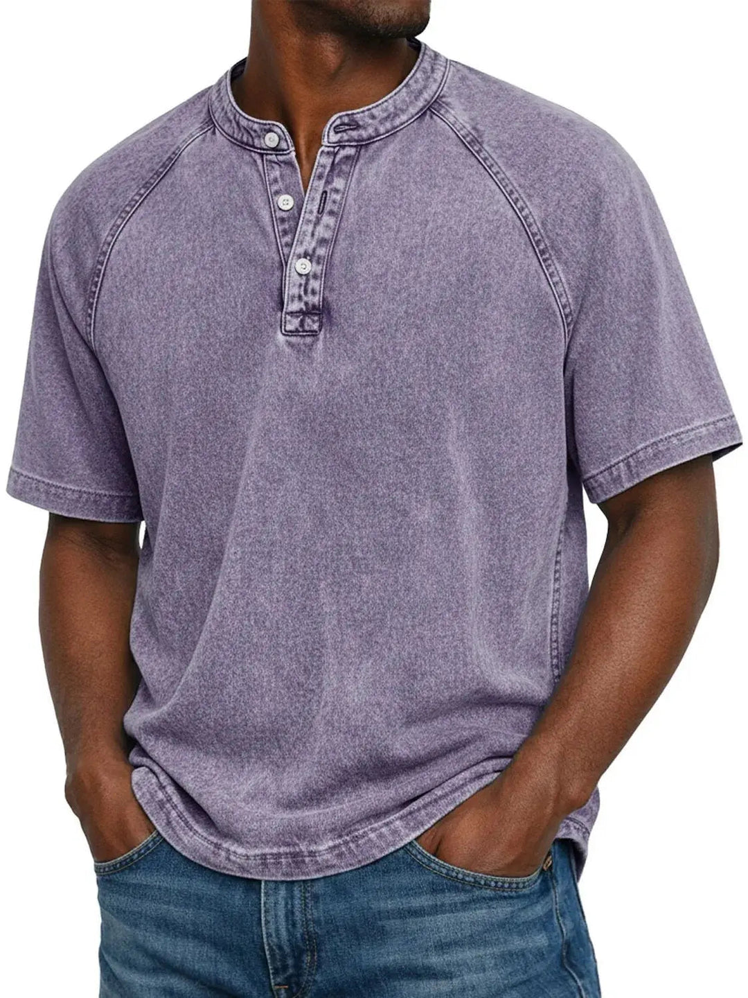 Homme portant le t-shirt Henley lavé violet lavande à manches raglan, trois boutons, mains dans les poches d'un jean. 1