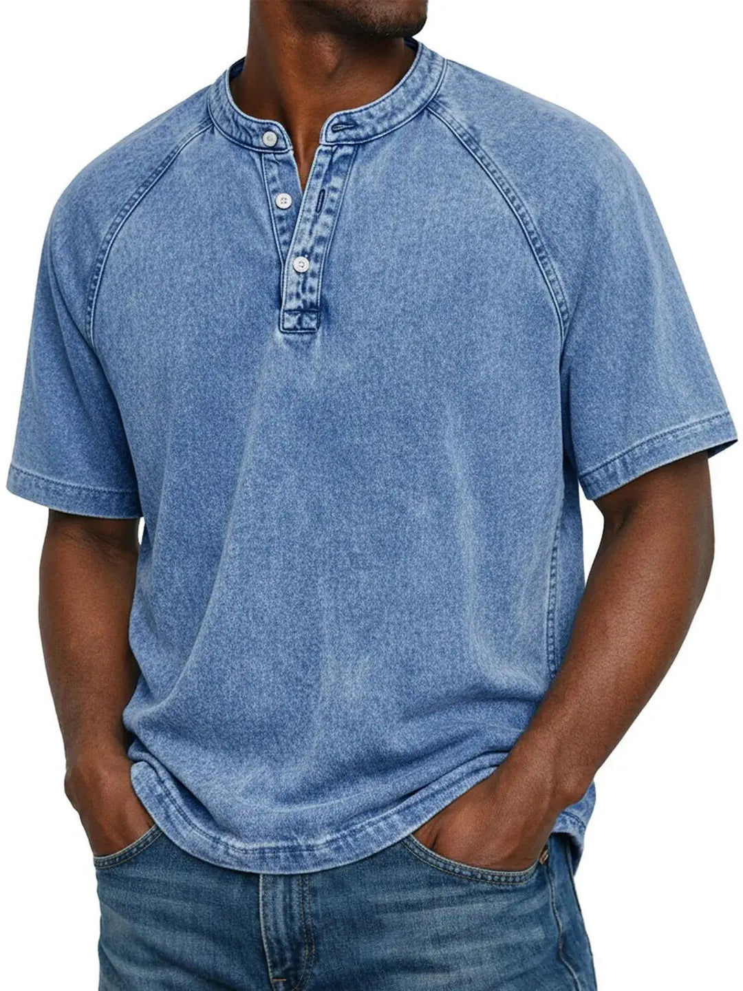 Homme portant le t-shirt Henley lavé bleu clair à manches raglan et col boutonné, mains dans les poches d'un jean. 2