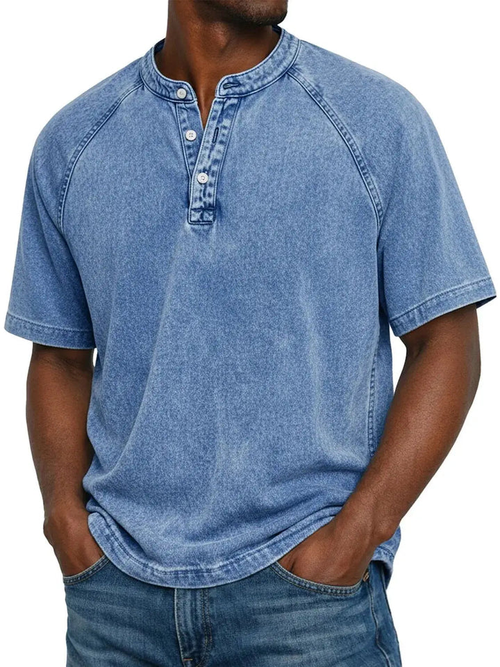 Homme portant le t-shirt Henley lavé bleu clair à manches raglan et col boutonné, mains dans les poches d'un jean. 2