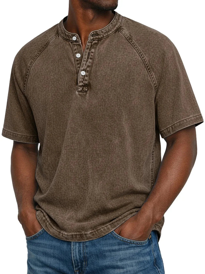 Homme portant le t-shirt Henley lavé marron à manches raglan et col boutonné, vu de face avec un jean. 8