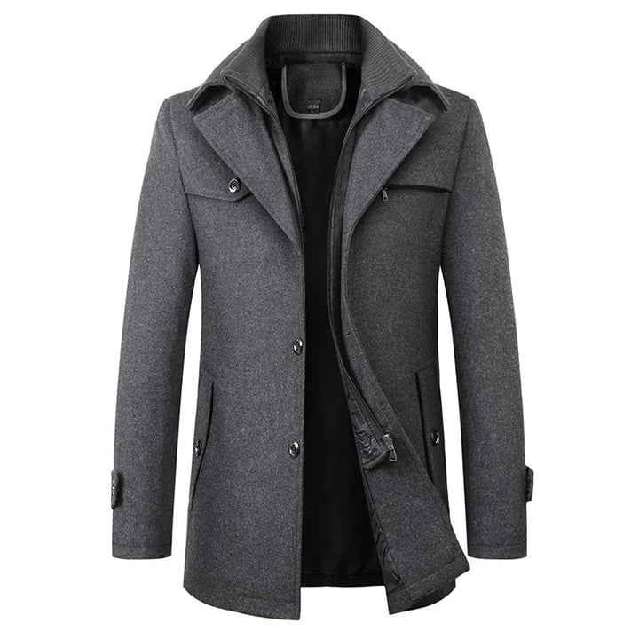 Vue de face du manteau gris chiné, couche intérieure zippée à col côtelé visible, boutons et pattes aux poignets. 2