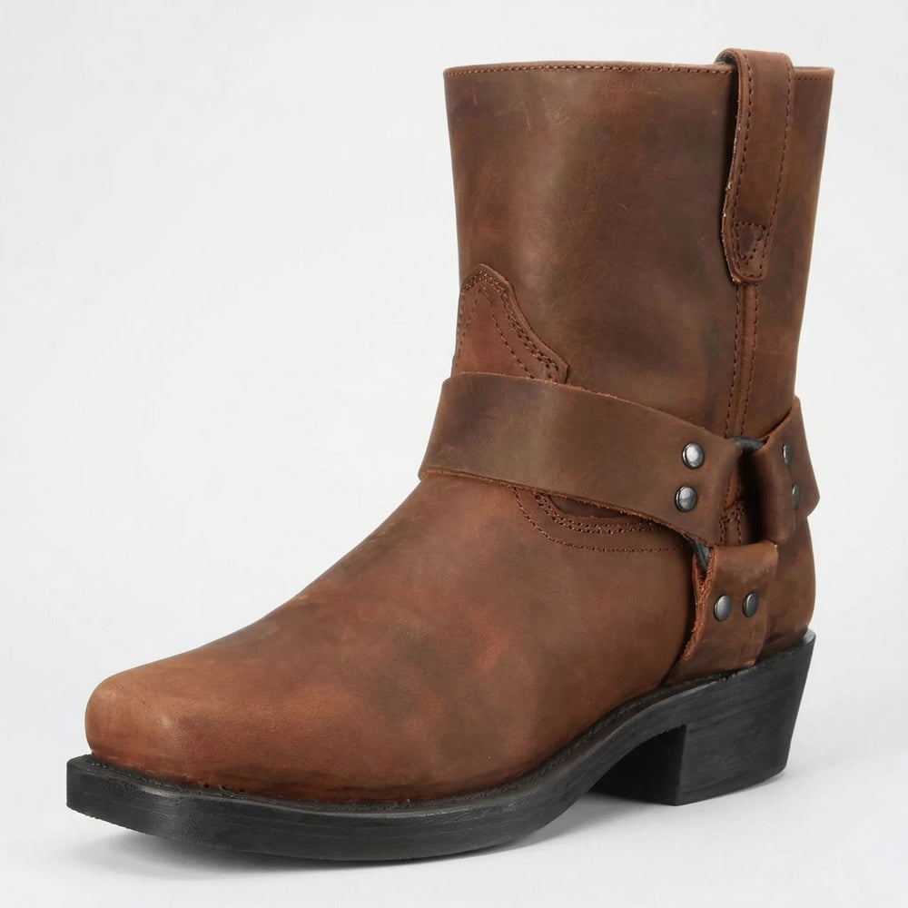 Botte en cuir marron vieilli, vue de trois quarts, avec sangle à anneau, rivets métalliques et talon noir. 2