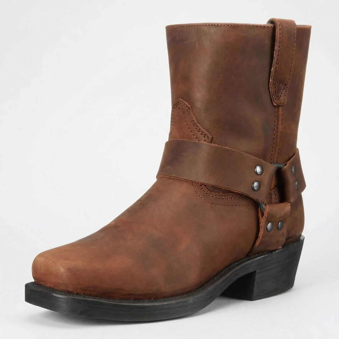 Botte en cuir marron vieilli, vue de trois quarts, avec sangle à anneau, rivets métalliques et talon noir. 2