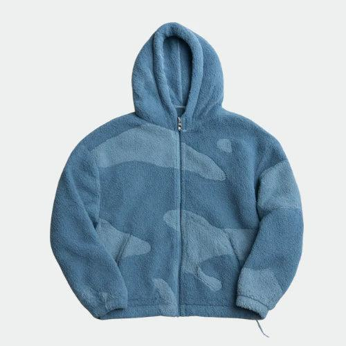 Veste zippée à capuche en polaire bleue, motif tonal à grandes zones de deux bleus, présentée à plat sur fond clair. 3