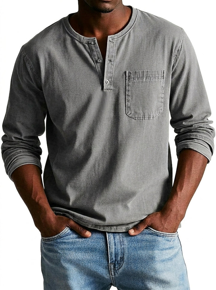 Chemise Henley grise portée par un modèle, mains dans les poches de son jean, poche poitrine plaquée sur le côté. 4