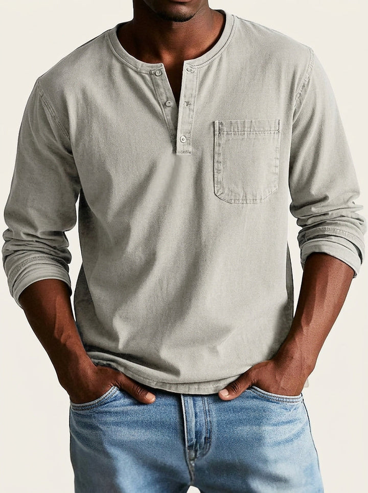 Chemise Henley gris clair beige portée de face sur fond crème, manches longues légèrement retroussées. 6