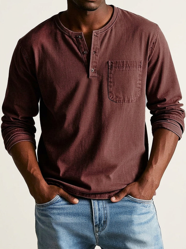 Chemise Henley bordeaux foncé portée de face, avec patte à boutons, poche poitrine et manches longues retroussées. 9