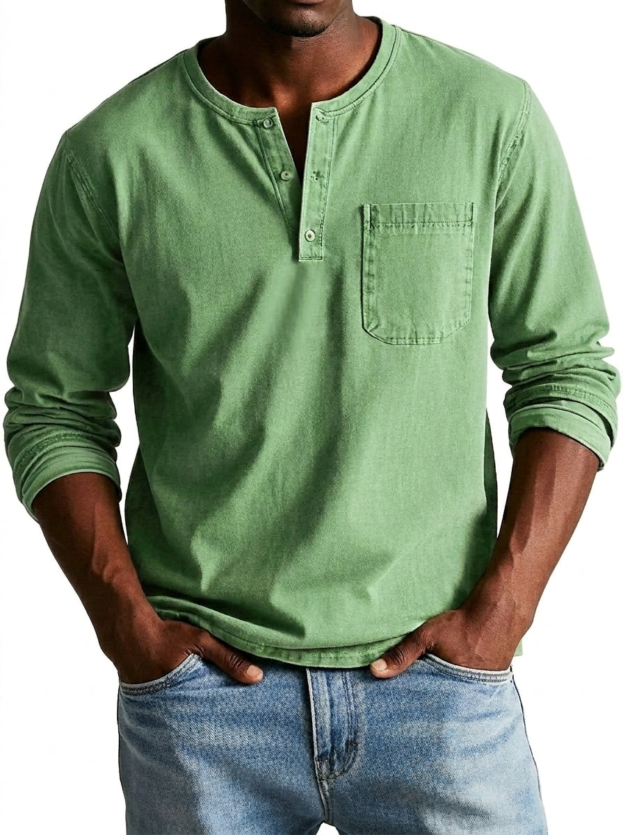 Homme portant la chemise Henley verte clair, mains dans les poches d'un jean bleu, vue de face avec poche poitrine. 1