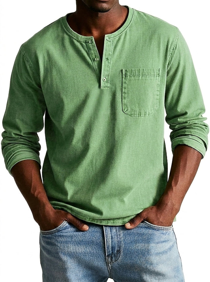 Homme portant la chemise Henley verte clair, mains dans les poches d'un jean bleu, vue de face avec poche poitrine. 1