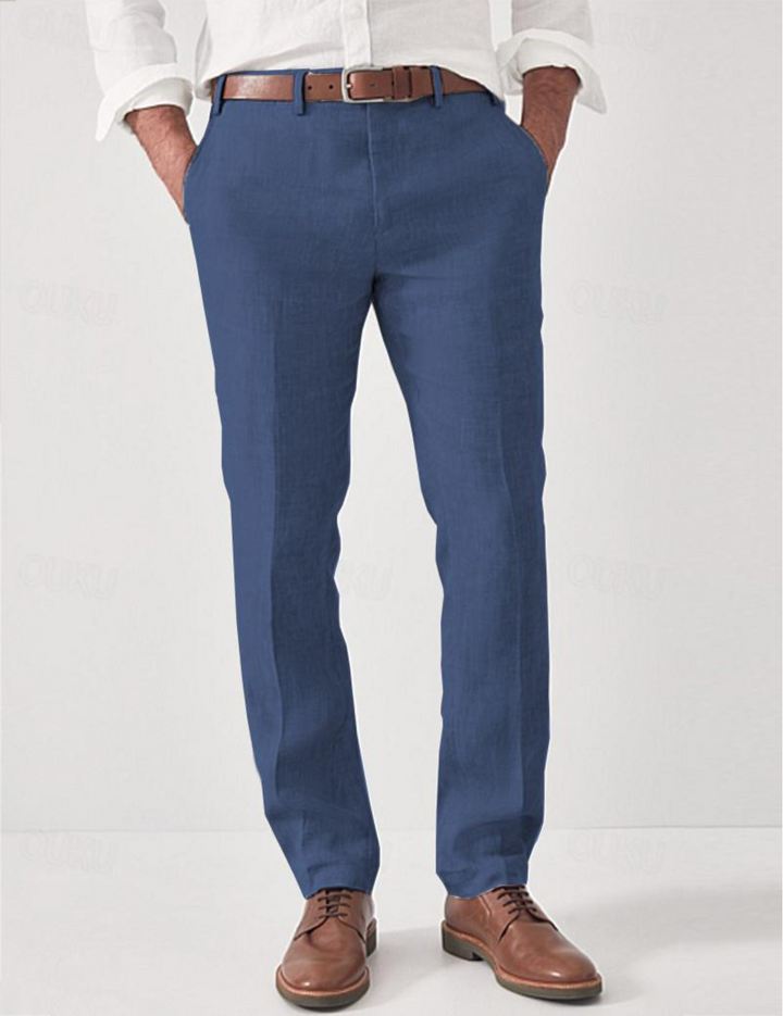 Pantalon en lin bleu porté de face par un modèle avec chemise blanche, ceinture marron et chaussures en cuir marron. 4