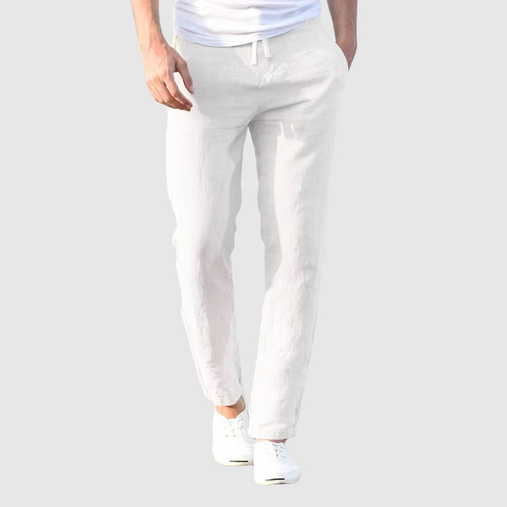Vue de face du pantalon blanc porté par un modèle en t-shirt blanc et baskets blanches, cordon à la taille. 6