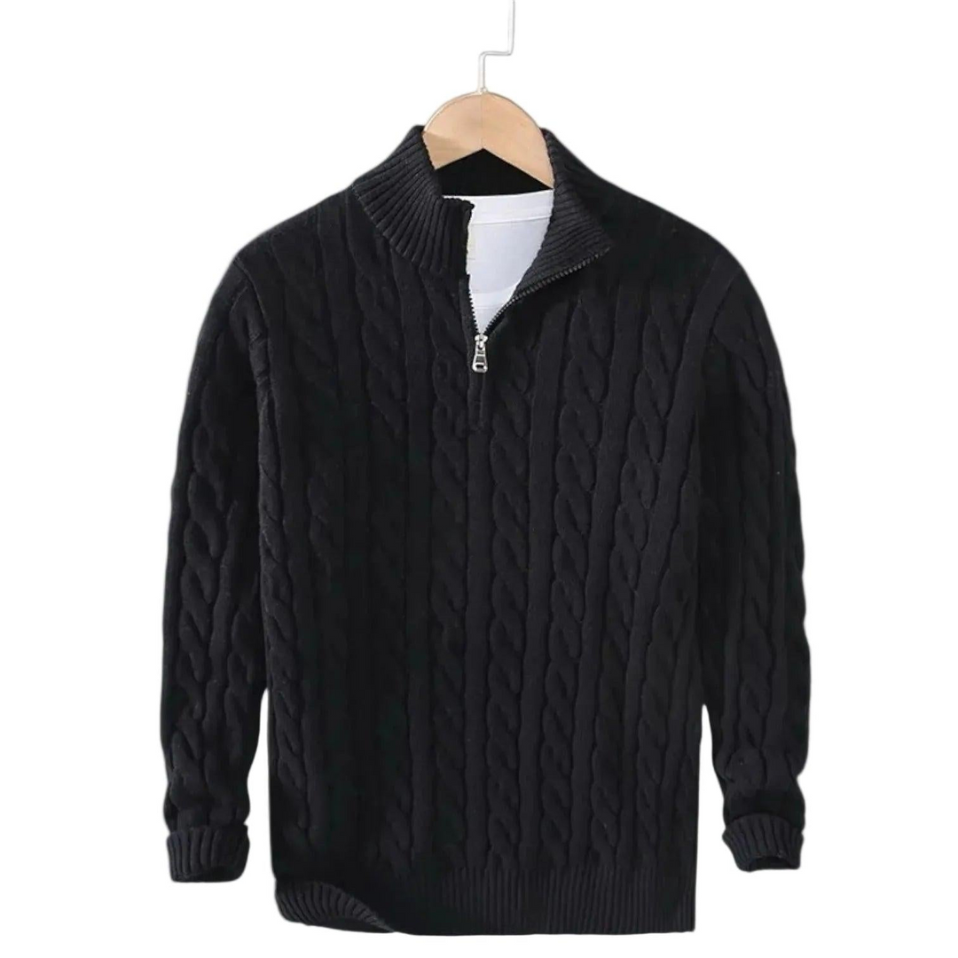 Pull noir en maille torsadée suspendu sur un cintre en bois, col montant à demi-zip ouvert sur un t-shirt blanc. 2