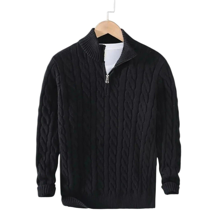 Pull noir en maille torsadée suspendu sur un cintre en bois, col montant à demi-zip ouvert sur un t-shirt blanc. 2