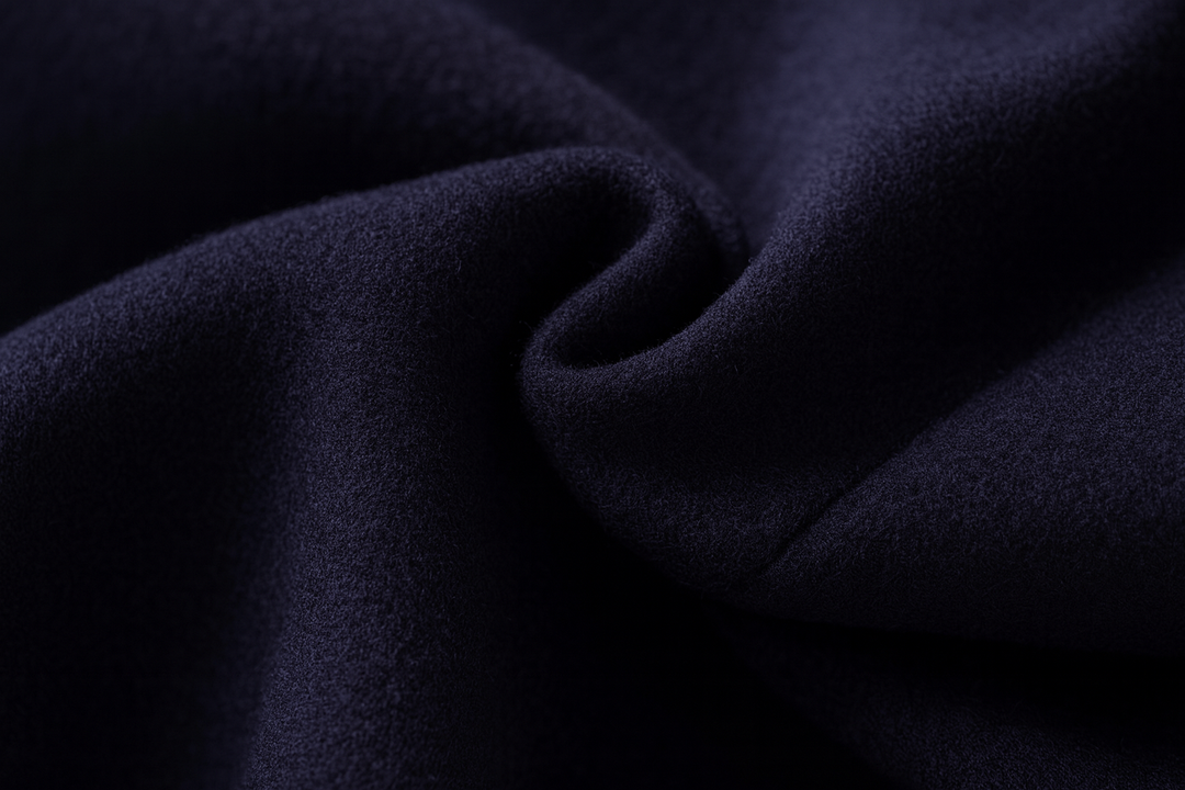 Gros plan sur le tissu de laine bleu marine, drapé en pli doux pour montrer sa texture 11