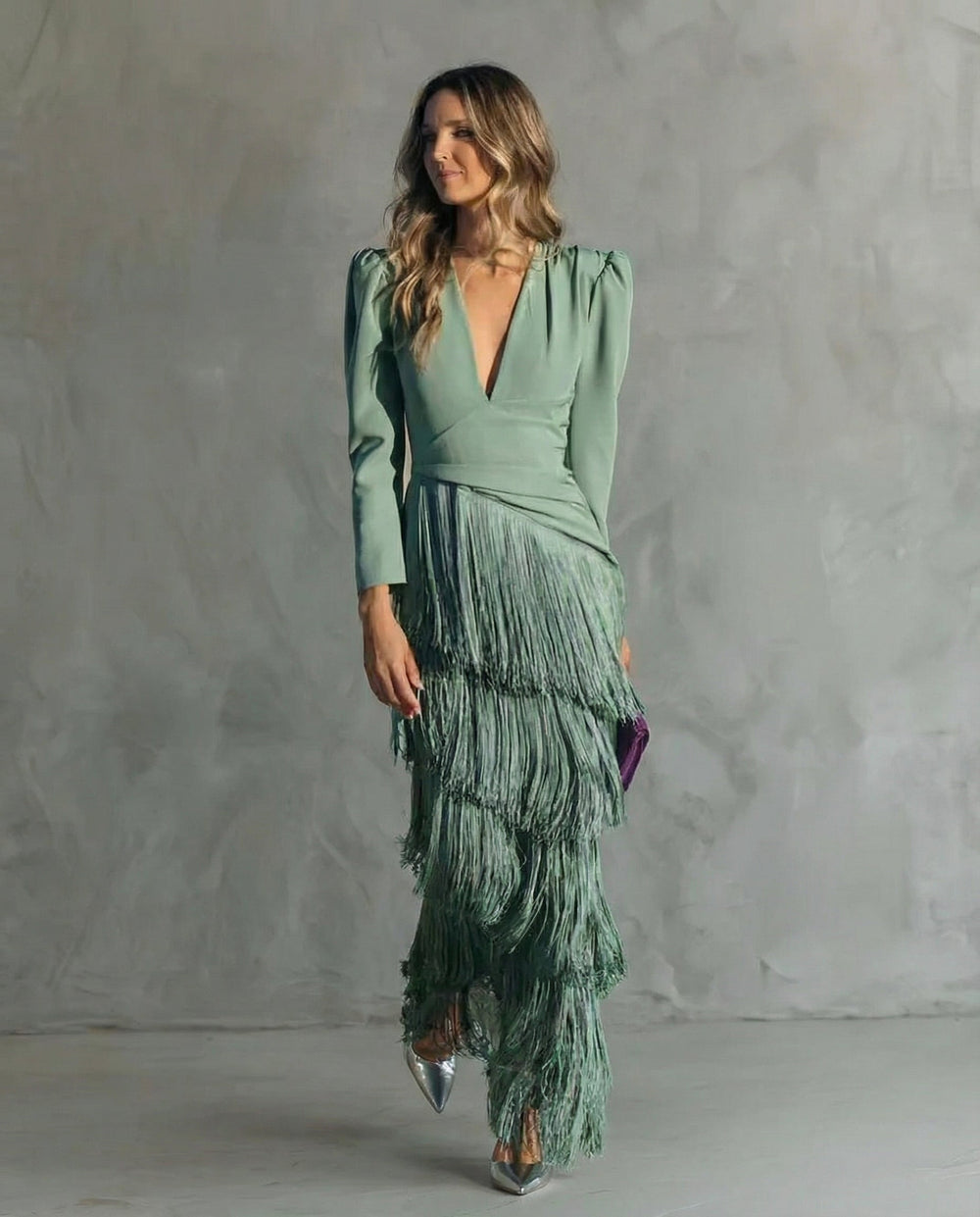 Mannequin en robe verte à franges, buste légèrement tourné, avec pochette violette et escarpins argentés 2