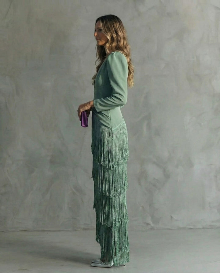 Robe verte à franges étagées vue de profil, manches longues et pochette violette en main 3