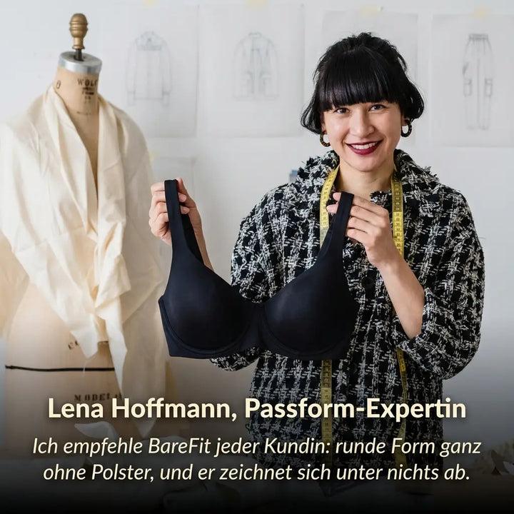 Femme souriante dans un atelier de couture tenant le soutien-gorge balconnet noir devant elle, mètre ruban au cou, mannequin de couture derrière. 5
