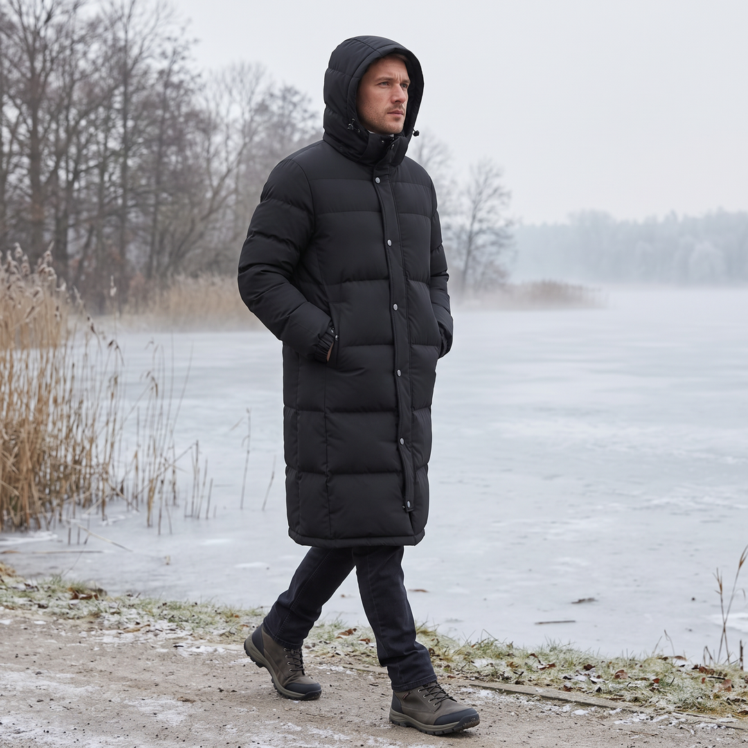 Homme portant le manteau noir à capuche, marchant au bord d'un lac gelé en hiver 2