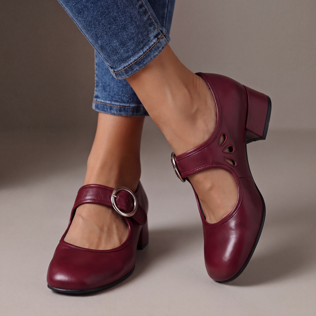 Escarpins bordeaux à talon bloc et boucle ronde argentée, portés avec un jean, découpes en goutte visibles sur le côté. 2