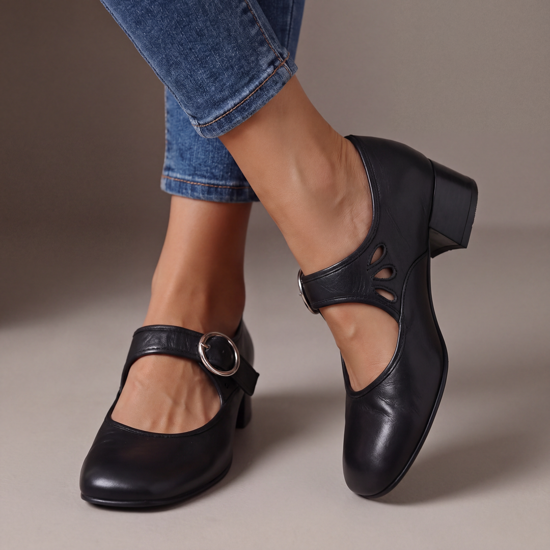 Escarpins noirs à talon bloc et boucle ronde argentée, portés avec un jean, détail des découpes en goutte sur le côté. 1