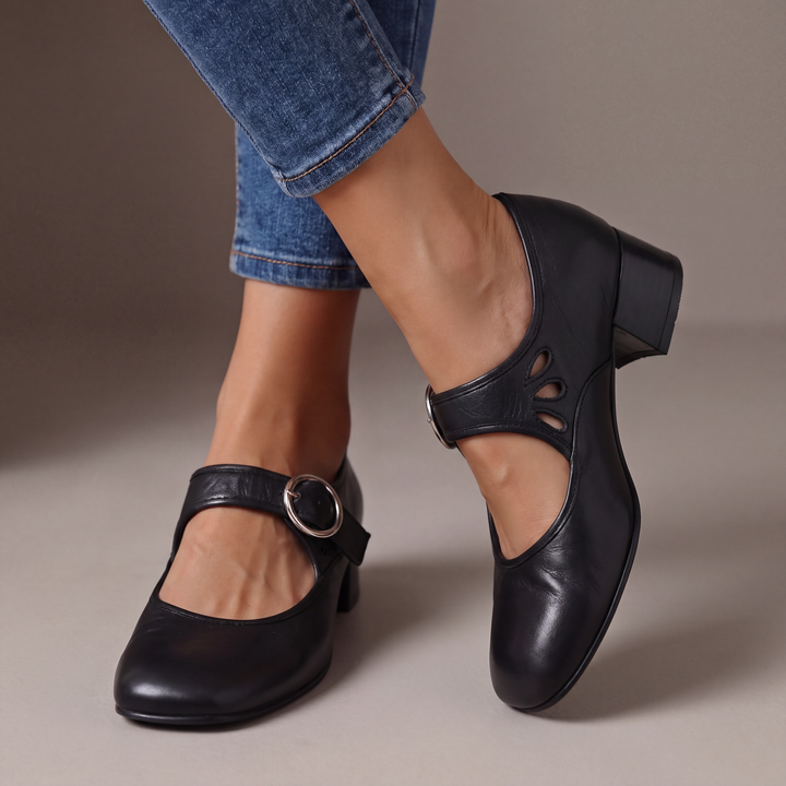 Escarpins noirs à talon bloc et boucle ronde argentée, portés avec un jean, détail des découpes en goutte sur le côté. 1