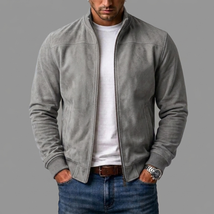 Homme portant le blouson en daim gris clair zippé ouvert sur un t-shirt blanc, avec jean bleu et bas côtelé. 7