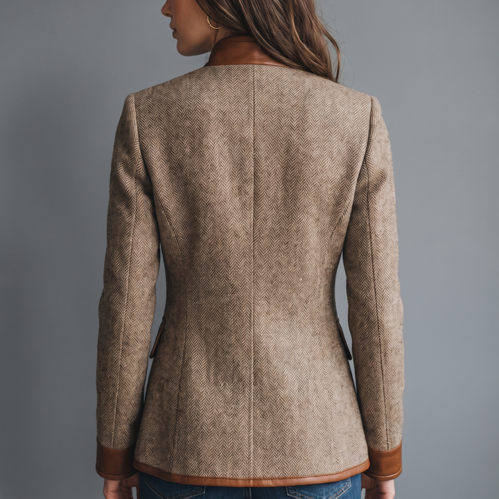 Veste vue de dos sur une mannequin : tweed à chevrons, couture centrale, col et bas de manches bordés de simili-cuir marron. 3